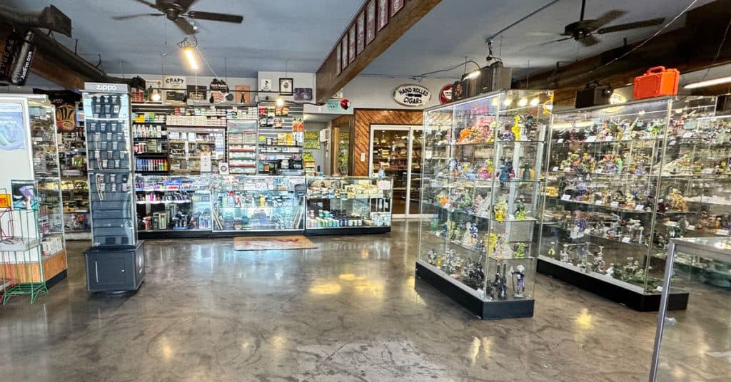 Smoke shop interior in Phoenix AZ with glass pipes and vape devices at It's All Goodz
